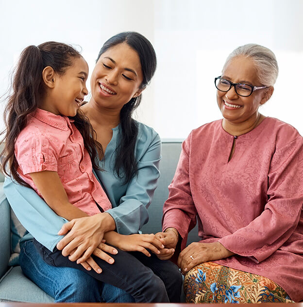 happy grandmother sitting with her daughter and granddaughter