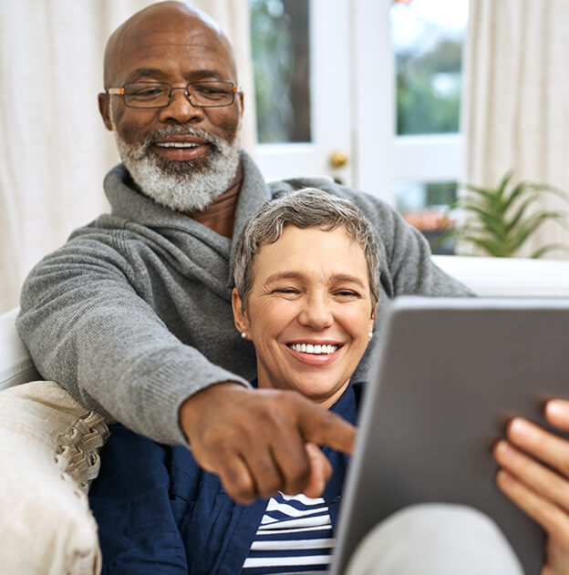 happy senior couple reading something on a tablet device