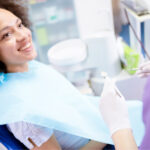 Brunette woman in the dental chair smiles before a tooth extraction in Mililani, HI