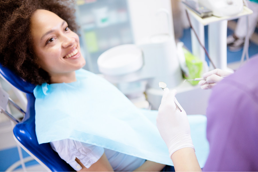 Brunette woman in the dental chair smiles before a tooth extraction in Mililani, HI