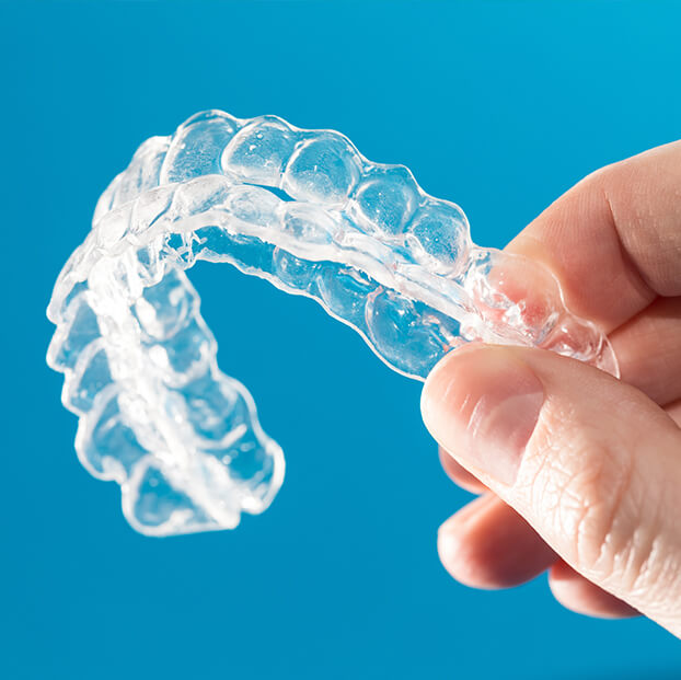 closeup of a person holding their clear aligners