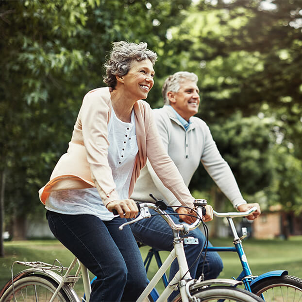 smiling senior couple riding bikes together