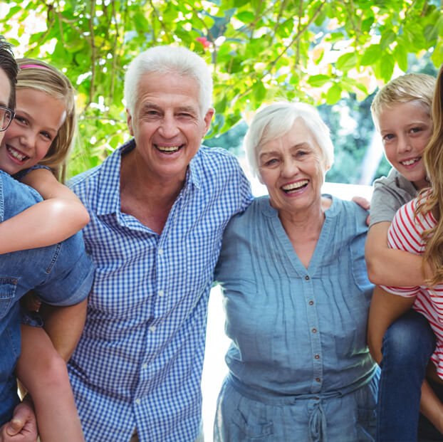 smiling senior couple surrounded by their kids and grandkids