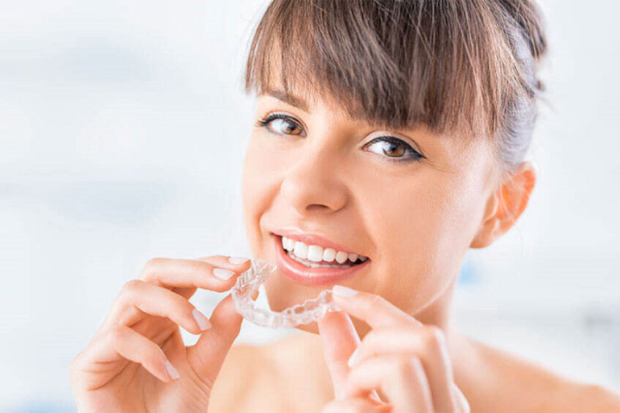 woman inserts her Invisalign clear aligner