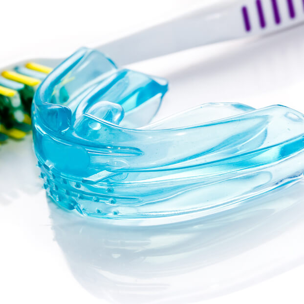 closeup of a mouthguard and a toothbrush