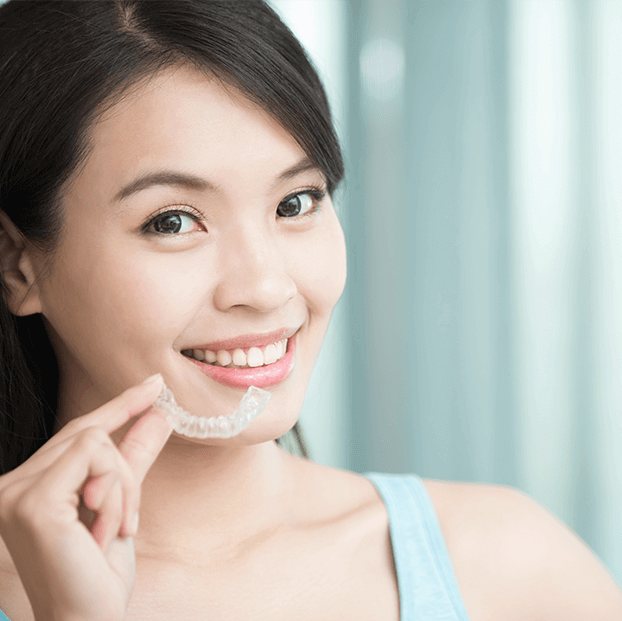 woman holding a clear aligner