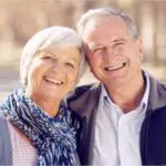 senior couple hug and smile after learning about dental bridges
