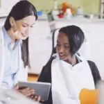 young woman visits with the dentist during a regular cleaning and exam