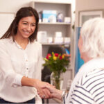 senior woman is greeted warmly by dental employeer,