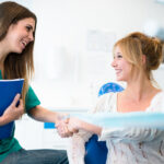 female dental patient learns about financing options from a female dental employee