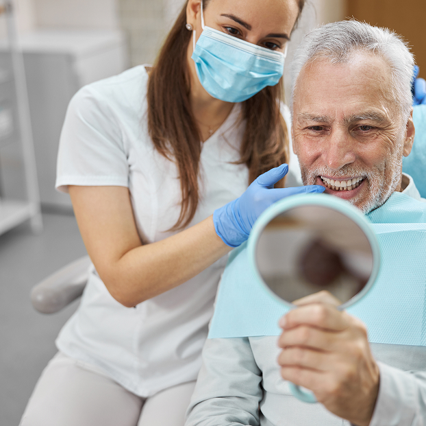 man at the dentist looking at his smile